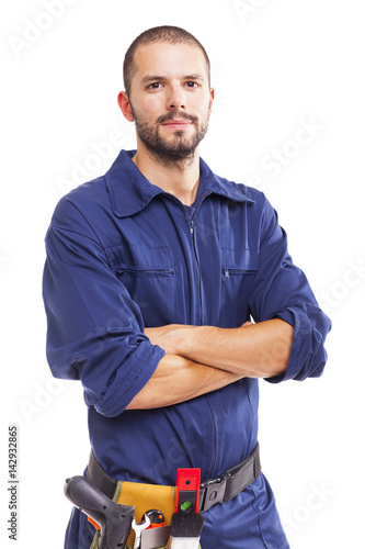 Young worker standing with arms crossed on white background