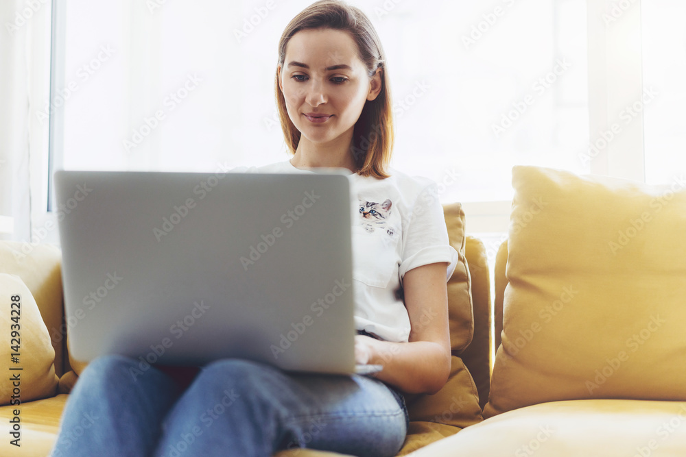 Young attractive business woman working on new project and siting on cozy sofa, Hipster girl working on a portable compute from home Young attractive business woman working on new project and siting on cozy sofa, Hipster girl working on a portable compute from home