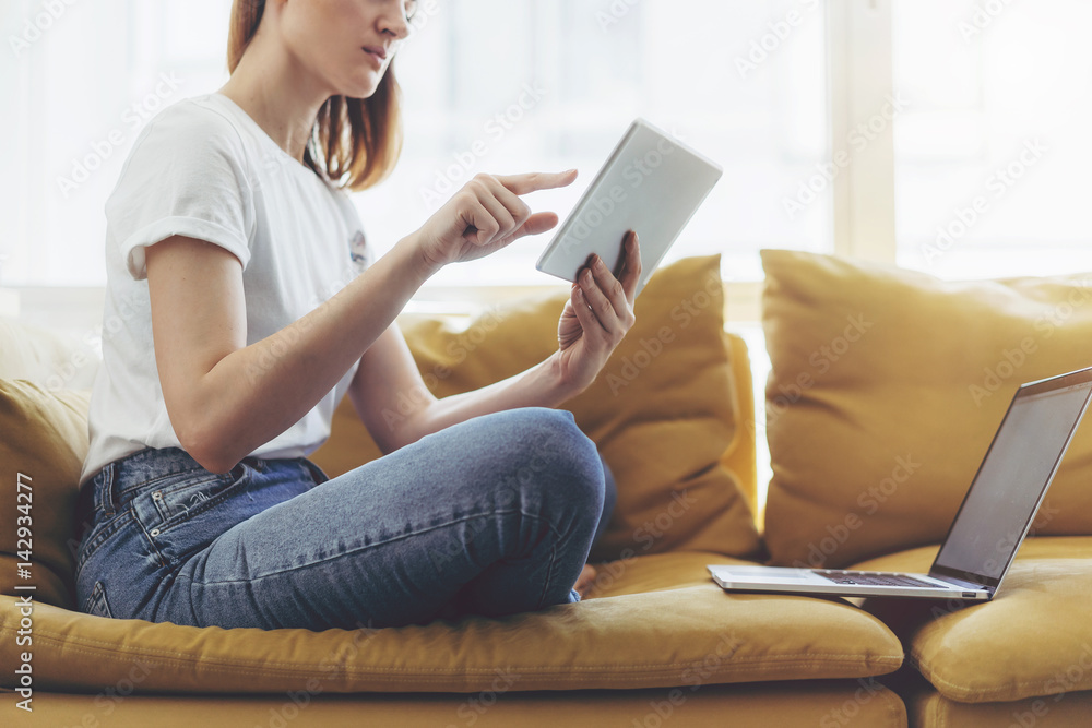 Hipster girl using digital tablet device and laptop while creating new project, Attractive female is typing messages on digital tablet device at home Hipster girl using digital tablet device and laptop while creating new project, Attractive female is typing messages on digital tablet device at home