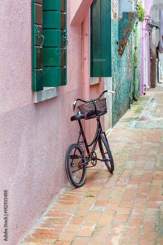Old bike on the wall on the island of Burano - Venice, Italy