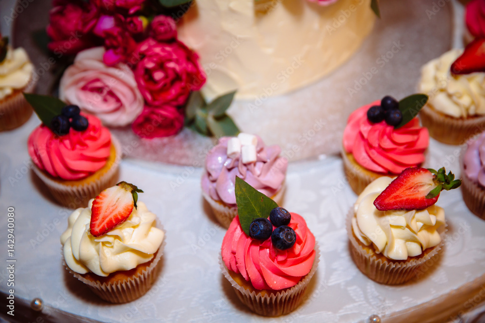 sweet wedding cake with candy bar, muffins, cakes and sweets in area of wedding party. Concept of advertising scenery of food and desserts sweet wedding cake with candy bar, muffins, cakes and sweets in area of wedding party. Concept of advertising scenery of food and desserts