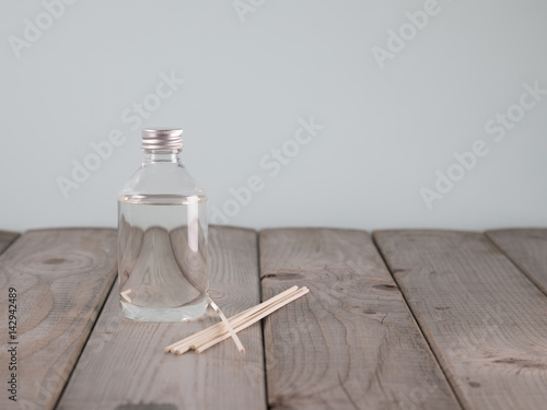 bottle of air freshener and sticks on wooden background
