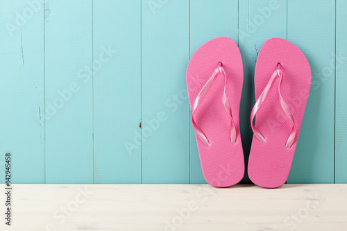 Pink flip flops on wooden background