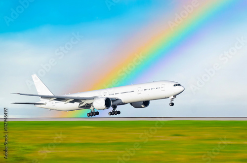 The airplane on the background of the rainbow landed at the airport