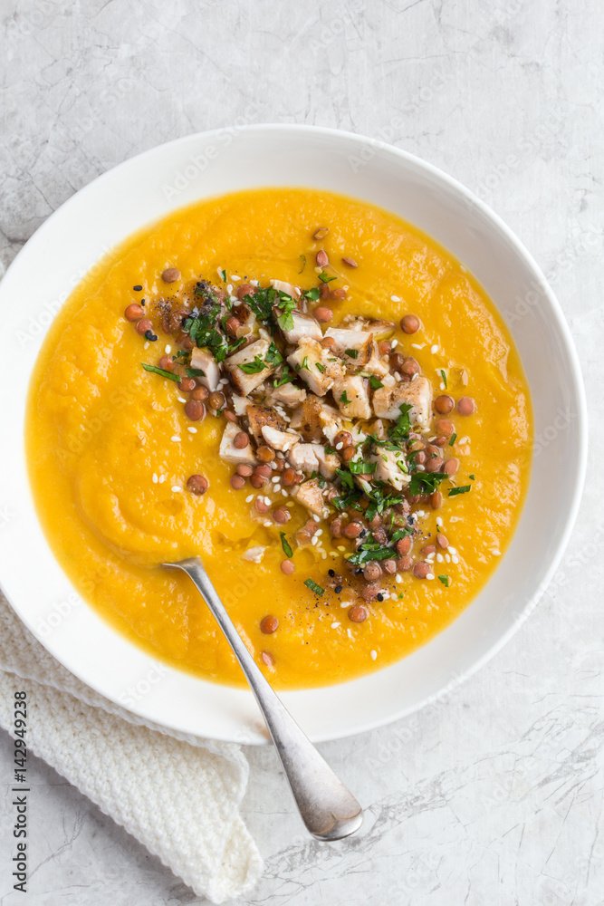 pumpkin and lentil cream soup in white bowl