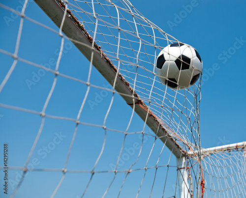 soccer ball in goal. isolated on blue sky background.