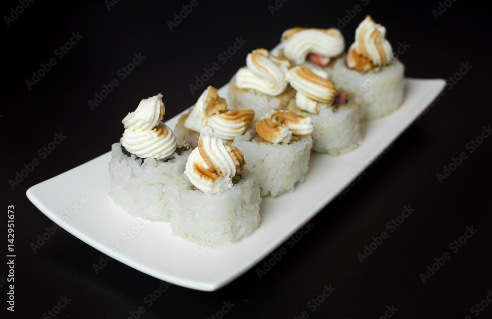 Sushi rolls with young cheese and trout on a black background Sushi rolls with young cheese and trout on a black background