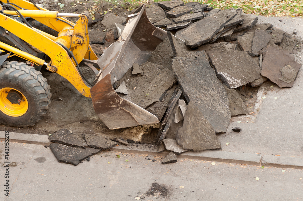 excavator removes the old asphalt excavator removes the old asphalt