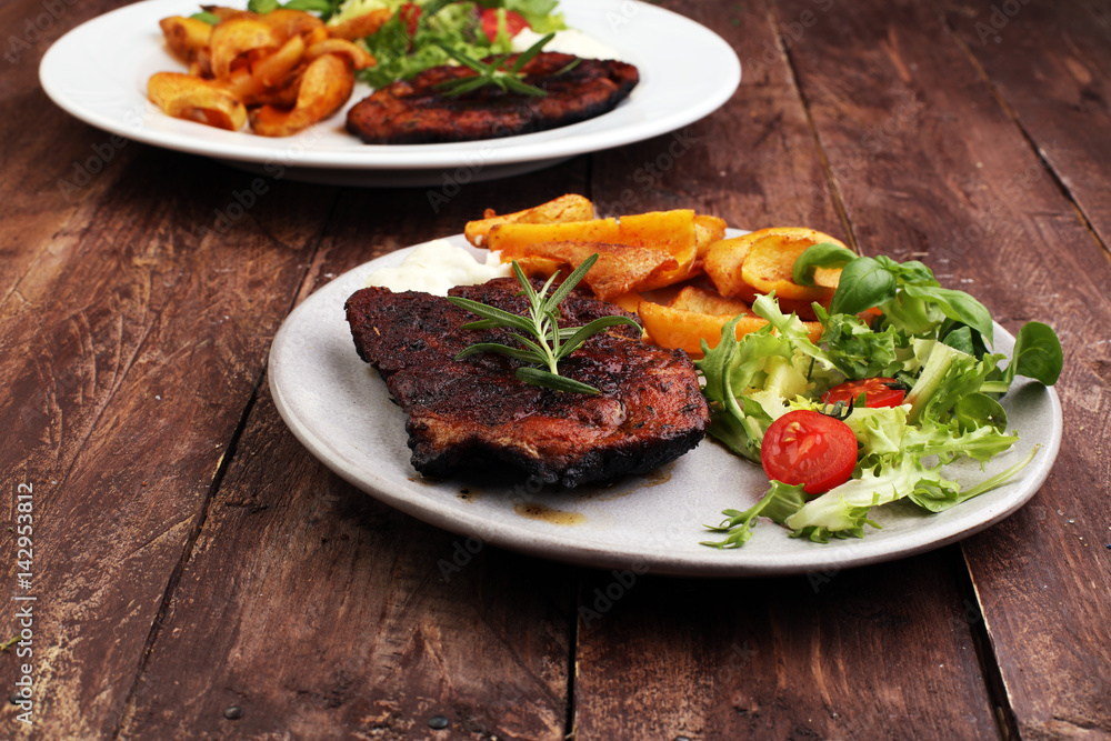 Grilled steaks, baked potatoes and salad Grilled steaks, baked potatoes and salad