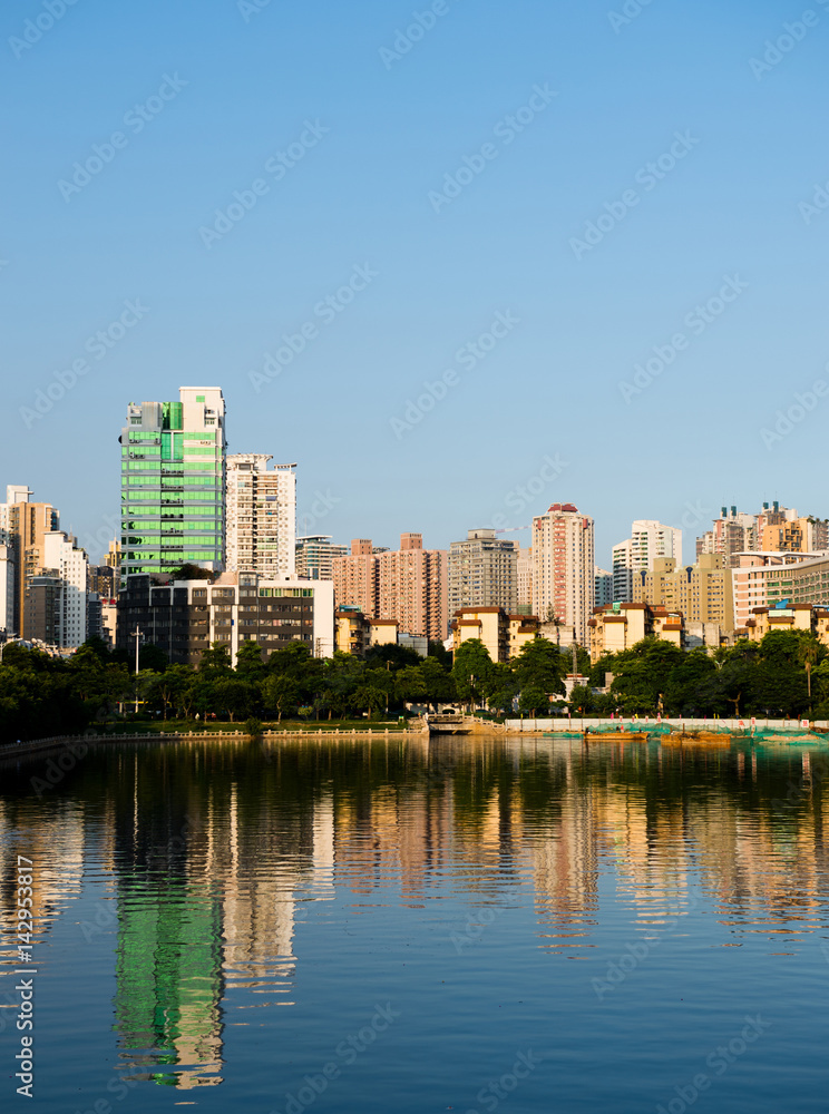 Buildings of a city with reflection in water. China