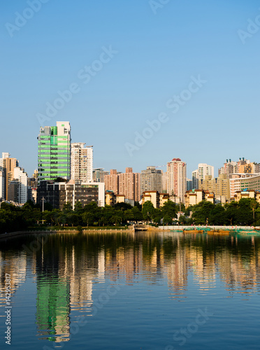 Buildings of a city with reflection in water. China