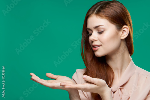 a woman on a green background does not show her hands to the side