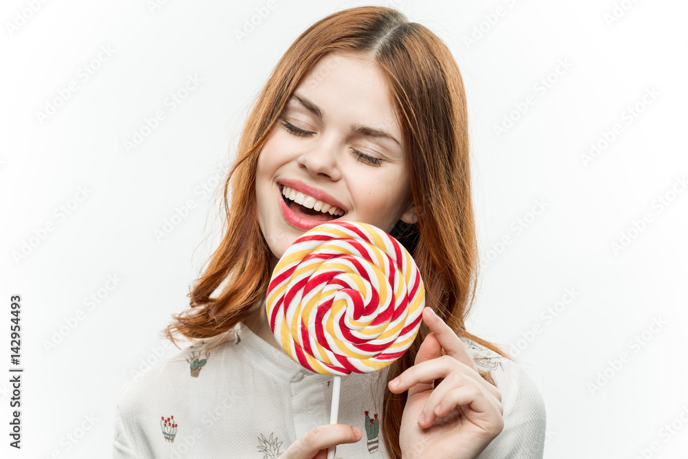 cheerful woman with a round face holds a candy finger