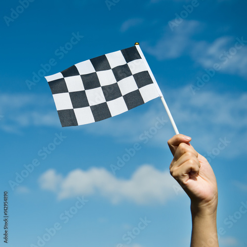 checkered race flag in hand. © xy