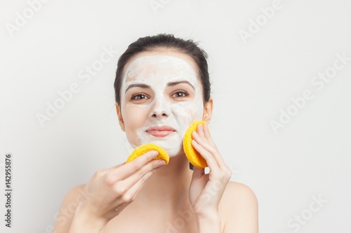 happy woman with a white mask on her face, yellow sponge