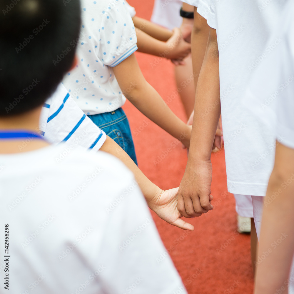 Group of children holding hands together..
