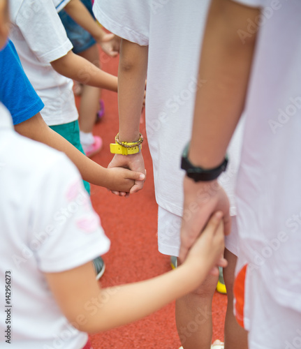Group of children holding hands together..