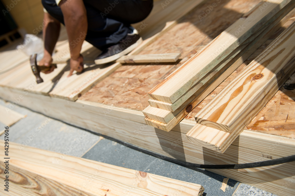 Man laying laminate flooring with tools. Man laying laminate flooring with tools.