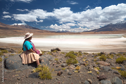 Bolivian woman in traditional costume on a high-altitude lagoon on the plateau Altiplano, Bolivia