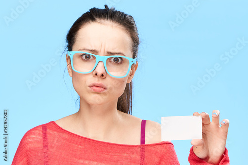 discouraged woman in blue glasses looks at the camera