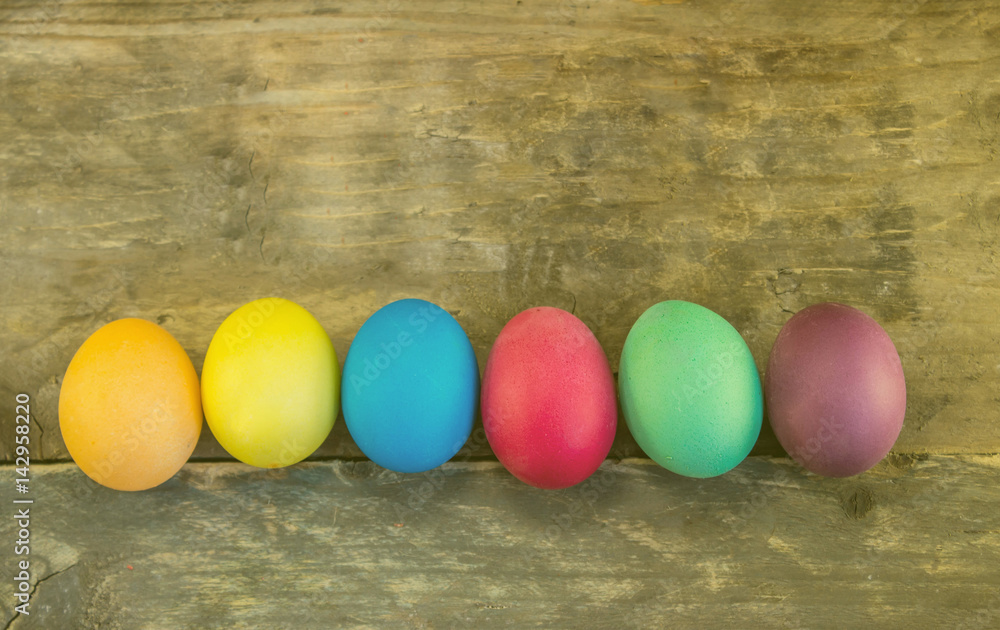 Row of colorful easter eggs on wooden planks Row of colorful easter eggs on wooden planks