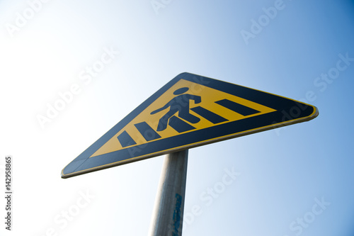 cross walk sign against blue sky.