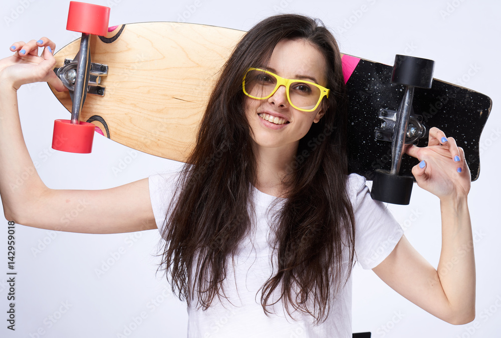 happy woman holding a skateboard behind her head, beautiful smile happy woman holding a skateboard behind her head, beautiful smile
