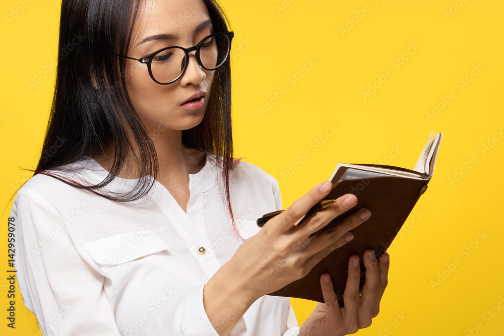 beautiful woman with glasses looks at a notebook, side view