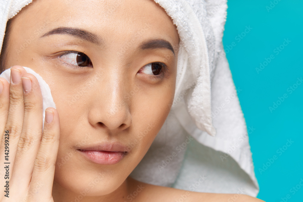 a woman wipes her face with a soft cotton pad a woman wipes her face with a soft cotton pad