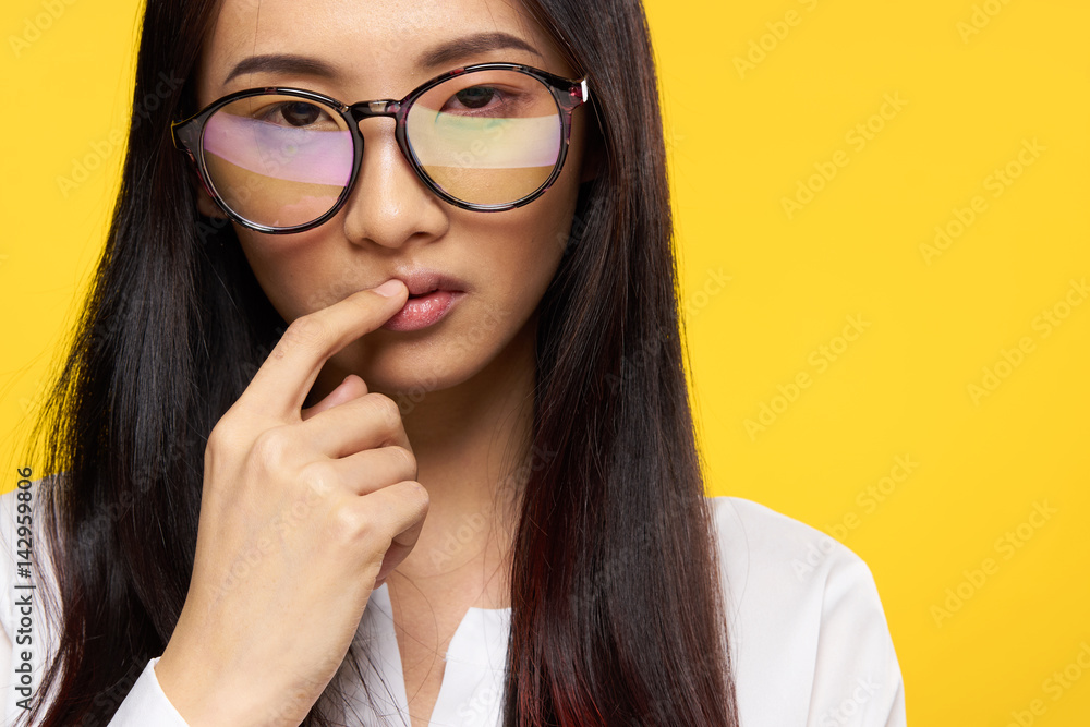 Puzzled look, woman in glasses on a yellow background Puzzled look, woman in glasses on a yellow background