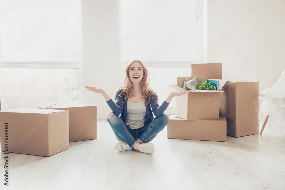 Woman unlimitedly happy because of moving new house of her dream, sitting on the floor with lots of cardboard boxes Woman unlimitedly happy because of moving new house of her dream, sitting on the floor with lots of cardboard boxes