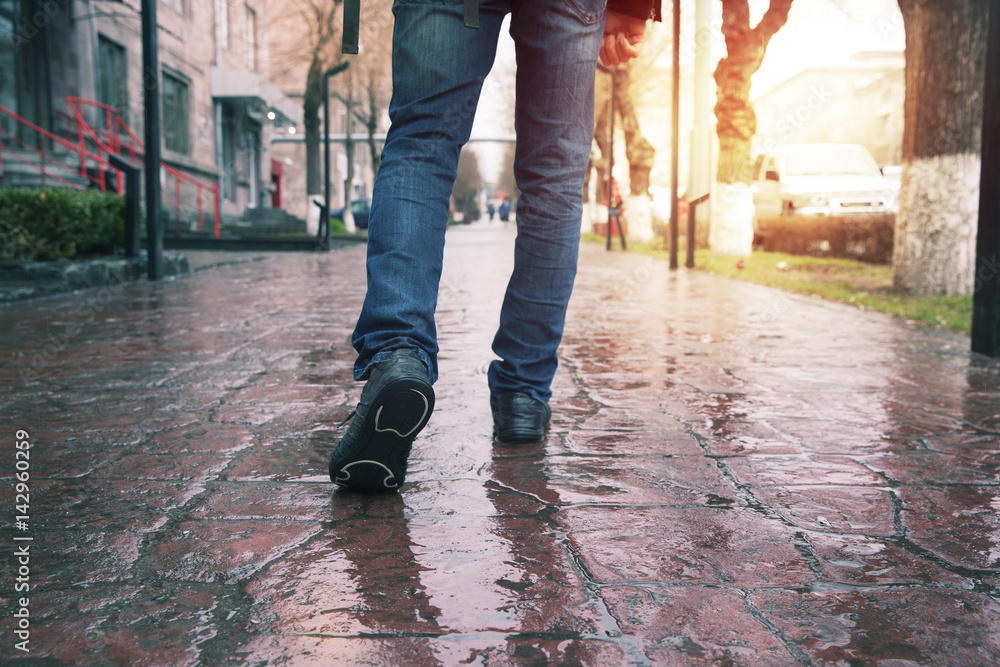 Man jeans and sneaker shoes walking on footpath Man jeans and sneaker shoes walking on footpath