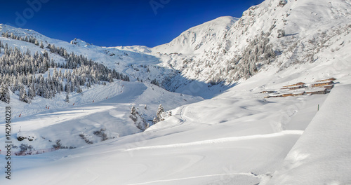 Trees and skiing slopes covered by fresh new snow in Tyrolian skiing resort  Zillertal arena, Austria. photo