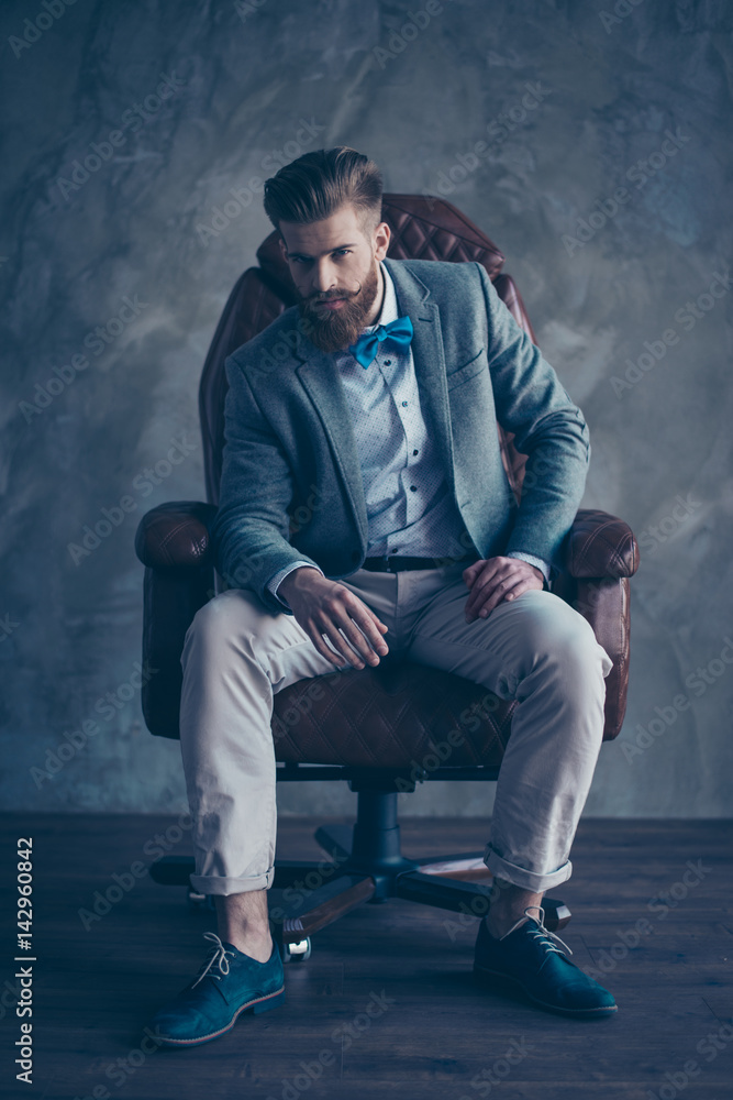 stylish serious minded brutal young man with red mustache, beard and  beautiful hairstyle ponder while sitting on comfortable office arm-chair  and wearing formal clothes and trendy shoes Stock Photo | Adobe Stock