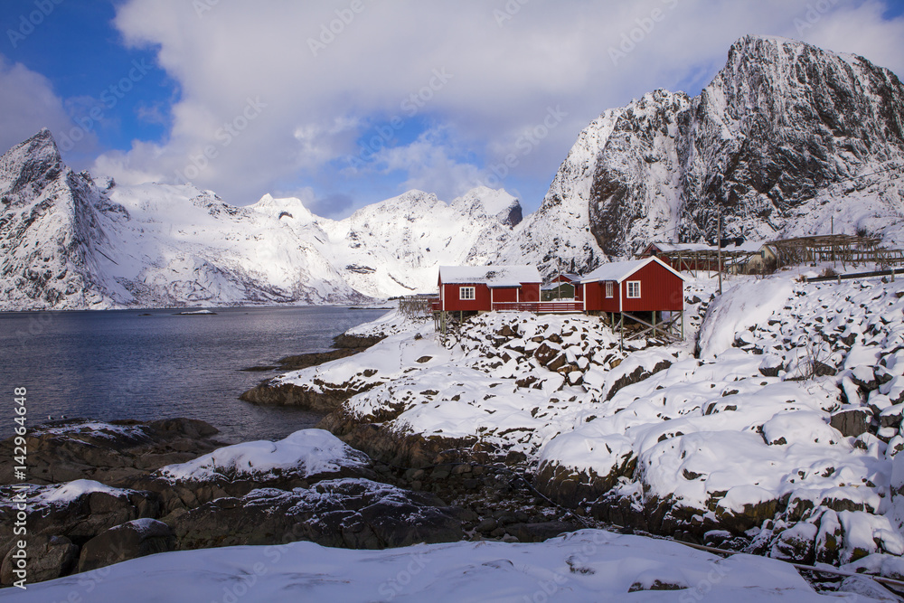 Fishing hut (rorbu) in the Hamnoy and Lilandstinden mountain peak at winter - Reine, Lofoten islands, Norway