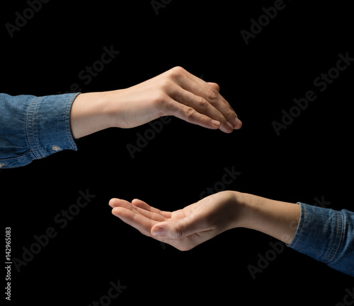 Isolated image of two hands on black background. Concept of protection, care and insurance.