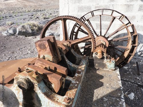 Rusty historic water pump in the dessert for agricultural means.