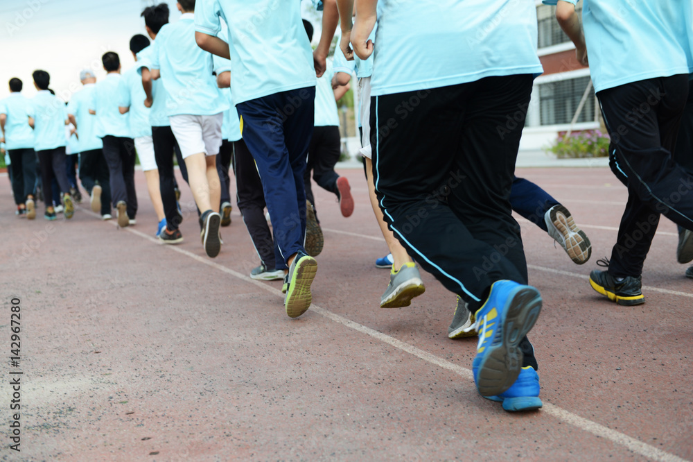Naklejka premium Group of students running on a racing track.