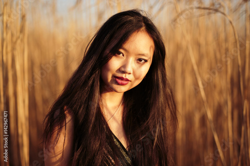 Obraz na płótnie beautiful young chinese woman with long dark hair and sultry looks set against a