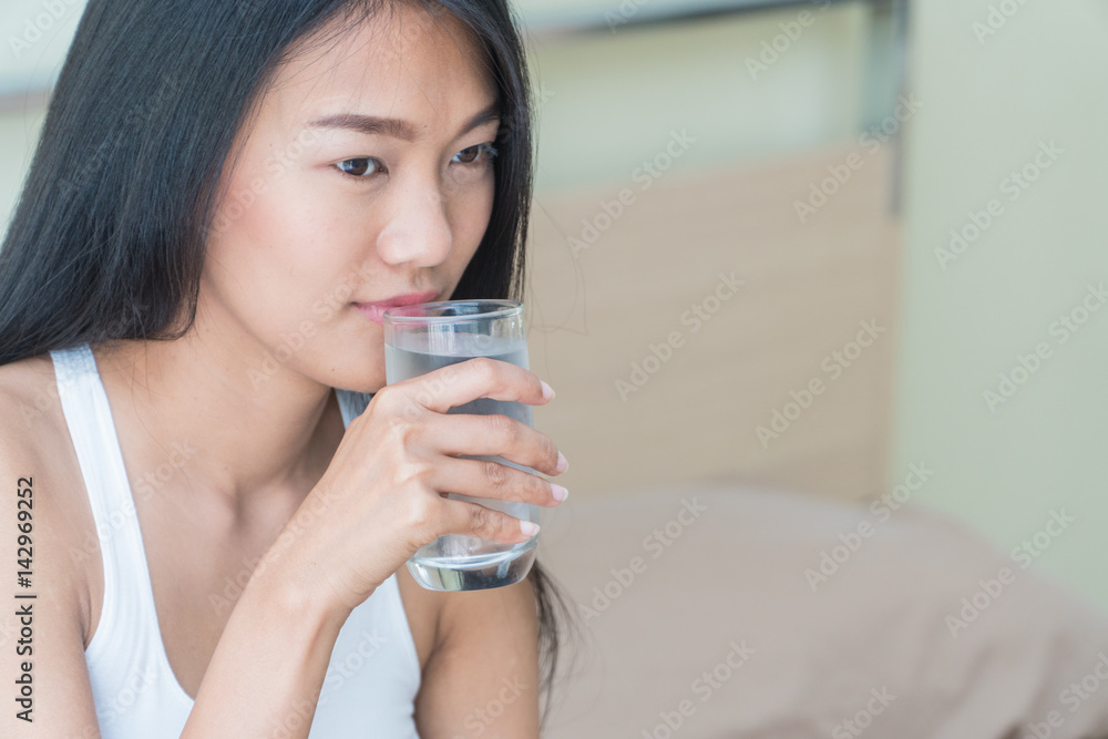 Beautiful woman holding a glass of water to drink in bed. Beautiful woman holding a glass of water to drink in bed.