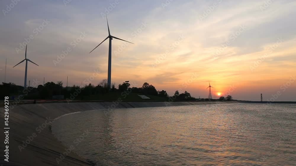 wind turbines creating green energy with reservoir at sunset wind turbines creating green energy with reservoir at sunset