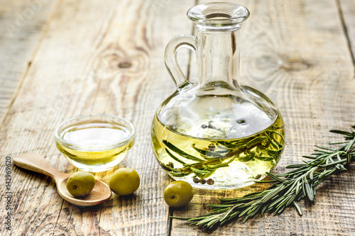 jar with oil with olives on wooden table background mock up