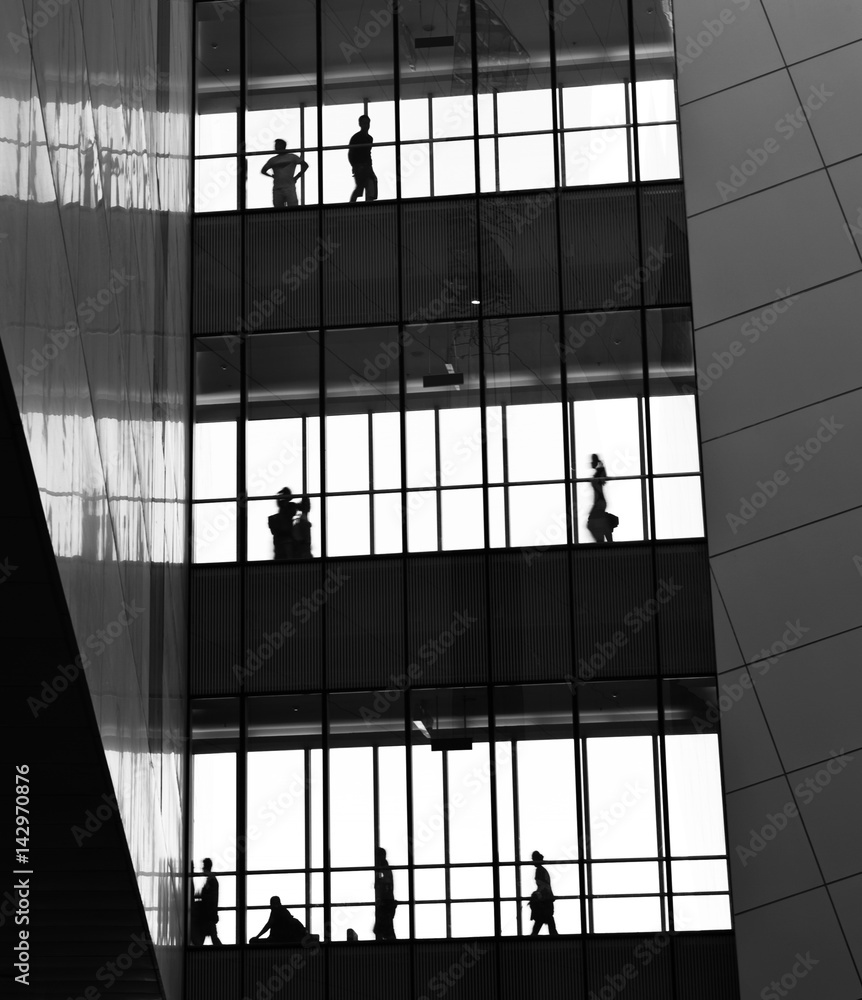 Fototapeta premium silhouettes of business people rushing at morden office building.