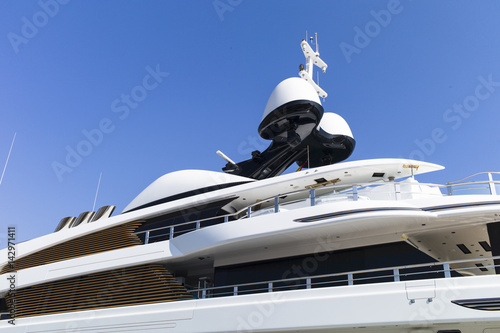 Modern yachts with massiv radar navigation systems at the stern at a jetty against blue skies