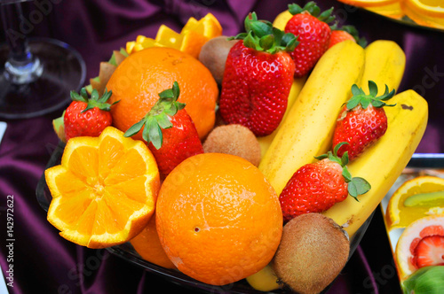 Sweet wedding table decorated with thin cutouts of strawberries  bananas  pineapple  kiwi  of grapefruit  oranges and raspberry