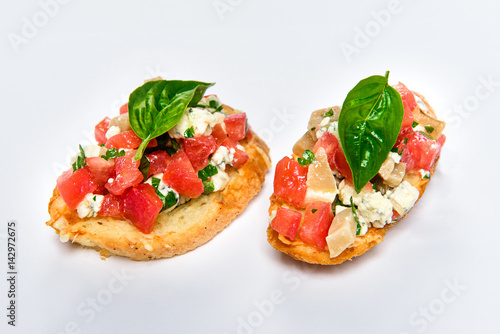 Two bruschettes with cheese Feta, basil and meat pieces