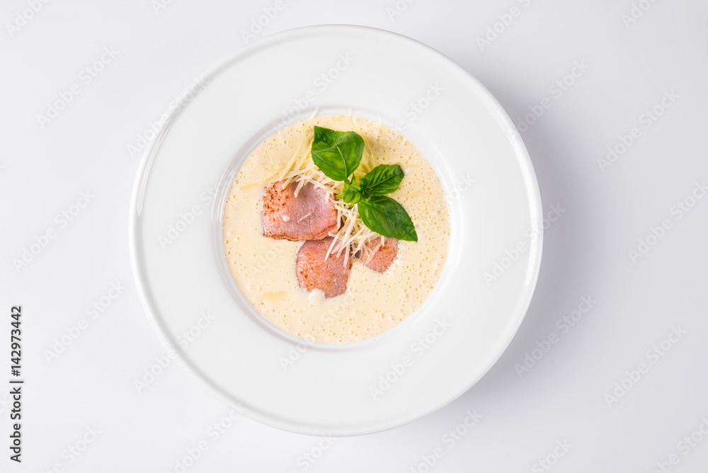 Cream soup with basil, meat steak and cheese on plate. Cream soup with basil, meat steak and cheese on plate.