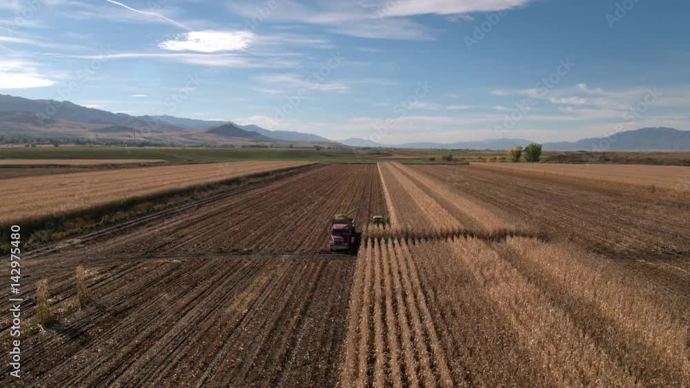 Aerial view flying over combine loading truck Aerial view flying over combine loading truck