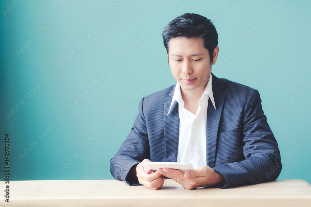 Asian business man using digital tablet while sitting at office table, business and technology Asian business man using digital tablet while sitting at office table, business and technology