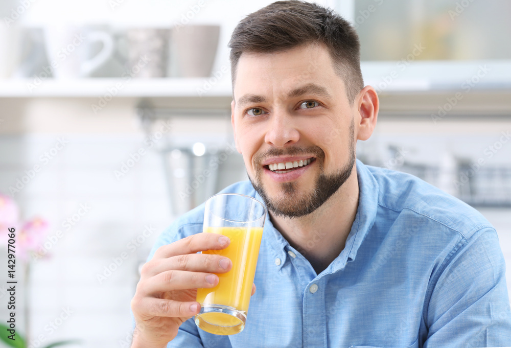 Handsome man with juice in kitchen Handsome man with juice in kitchen